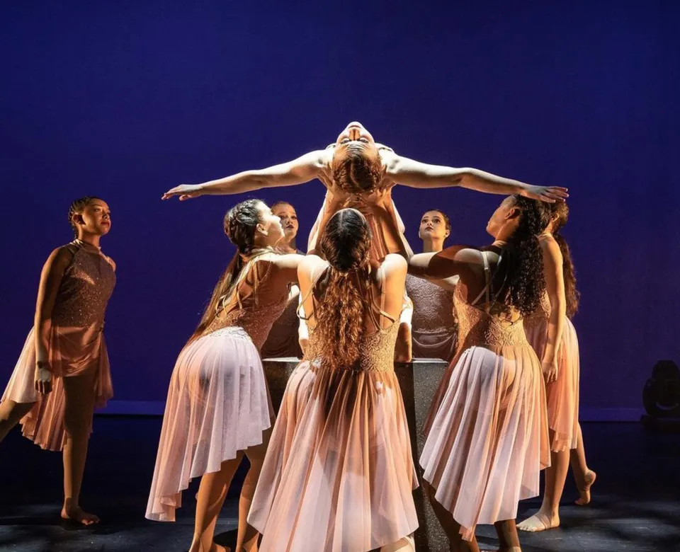 Un gruppo di ballerine in abiti chiari si esibisce sul palco della Calvary Christian Academy.