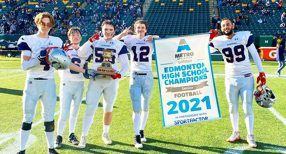 Studenti della Lillian Osborne High School sul campo sportivo con uno striscione per i campioni di football del 2021.