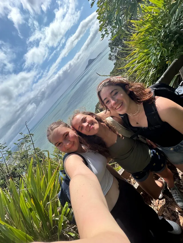Selfie de tres chicas en un sendero junto a la costa con el mar al fondo