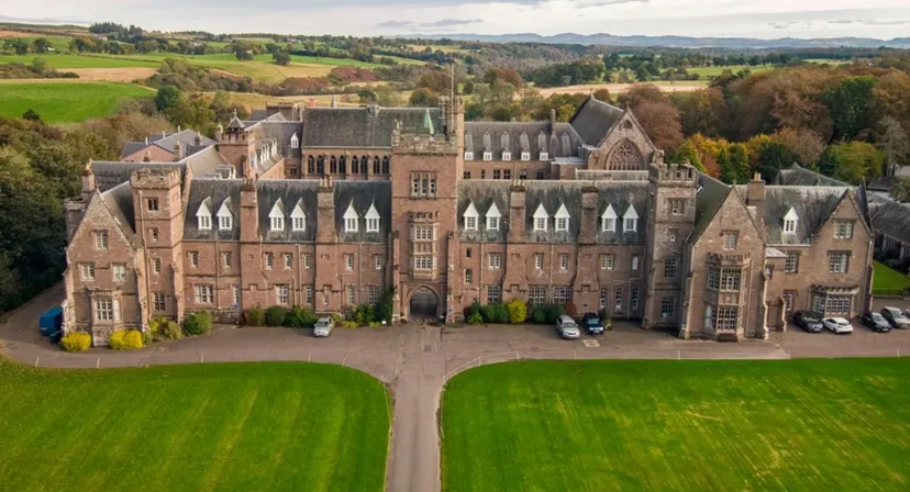 L'edificio storico a castello del Glenalmond College sorge in un vasto paesaggio con prati ben curati e giardini.
