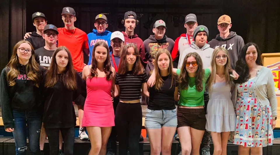Un gruppo di studenti si trova insieme su un palco nel campus della Laval High School.