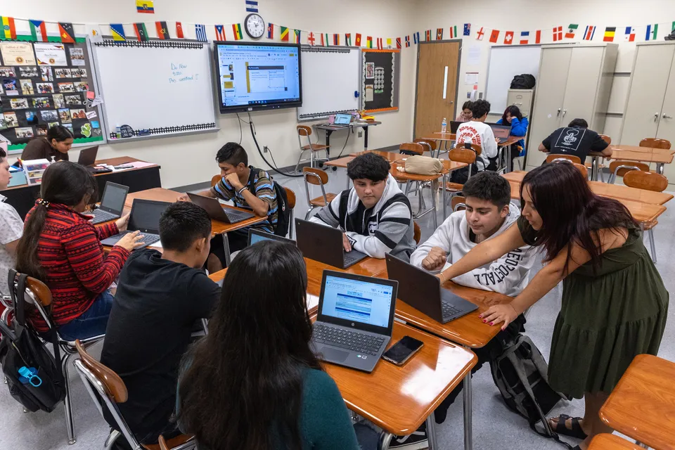 Studenti delle Charlotte-Mecklenburg Schools lavorano al computer in aula, circondati da materiale didattico.