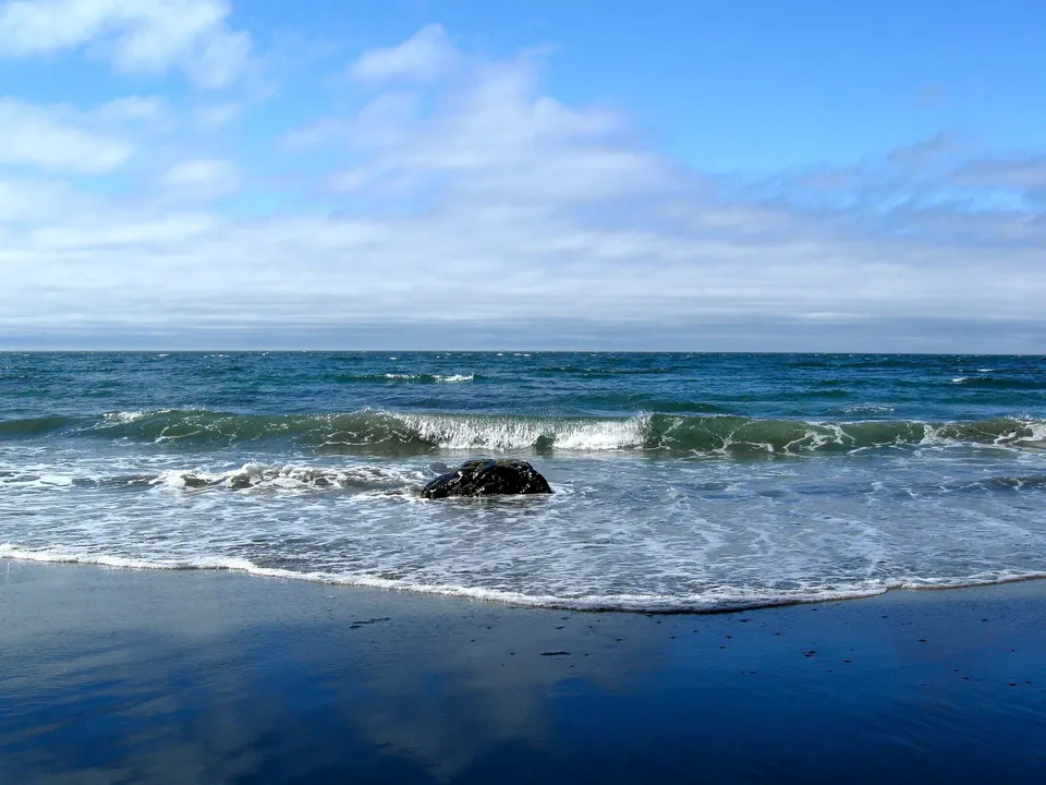 Un tranquillo paesaggio costiero con onde e spiaggia di sabbia senza un riferimento diretto alla Timberline Secondary School.
