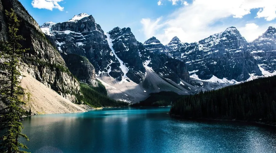 Un lago alpino turchese circondato da cime innevate e un paesaggio verdeggiante all'interno del terreno della Huntsville School.