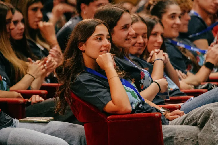 Studenti seduti in platea sorridono durante un evento di preparazione alla partenza per l'anno all'estero