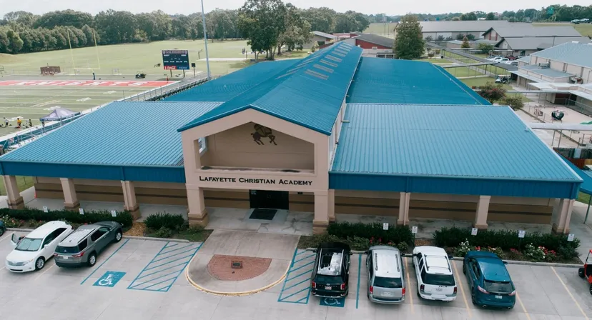 L'edificio principale della Lafayette Christian Academy con tetto in metallo blu e parcheggio in un contesto rurale.