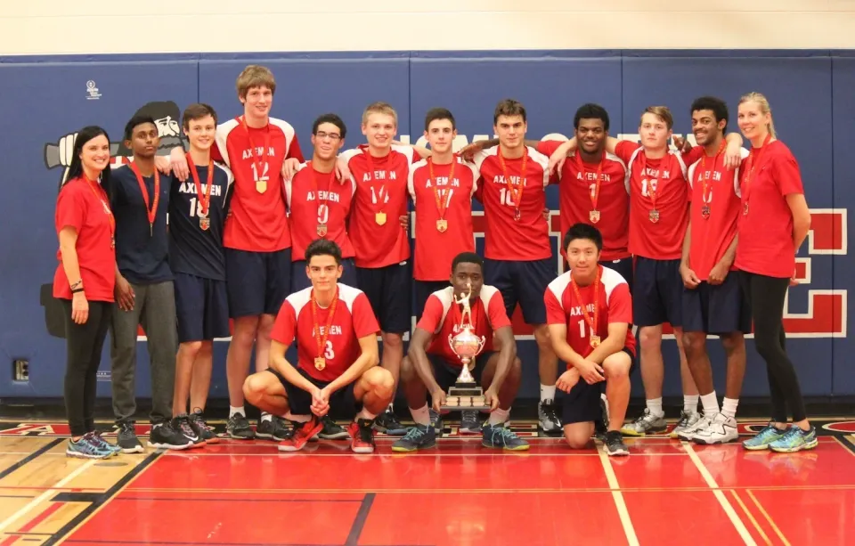 Gruppenbild von der Volleyballmannschaft mit deren Pokal und Medallien
