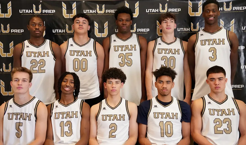 Un gruppo di giovani giocatrici e giocatori di basket della Utah Prep Academy posa davanti a uno sfondo con il logo.