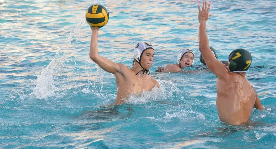 Due studenti della St. Brendan’s Community School giocano a pallavolo in piscina in una giornata di sole.