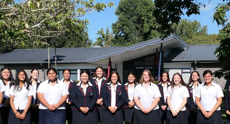 Un gruppo di studentesse in divisa scolastica si trova davanti a un edificio con il tetto in metallo nel campus della Hastings Girls' High School.