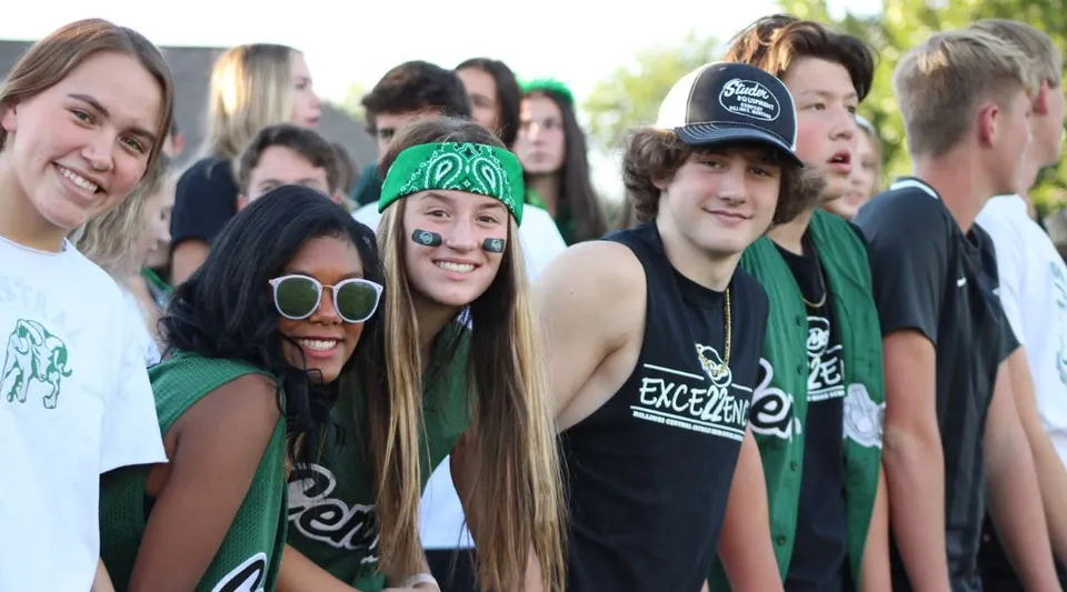 Un gruppo di studenti della Billings Central Catholic High School si riunisce all'aperto e sorride insieme.