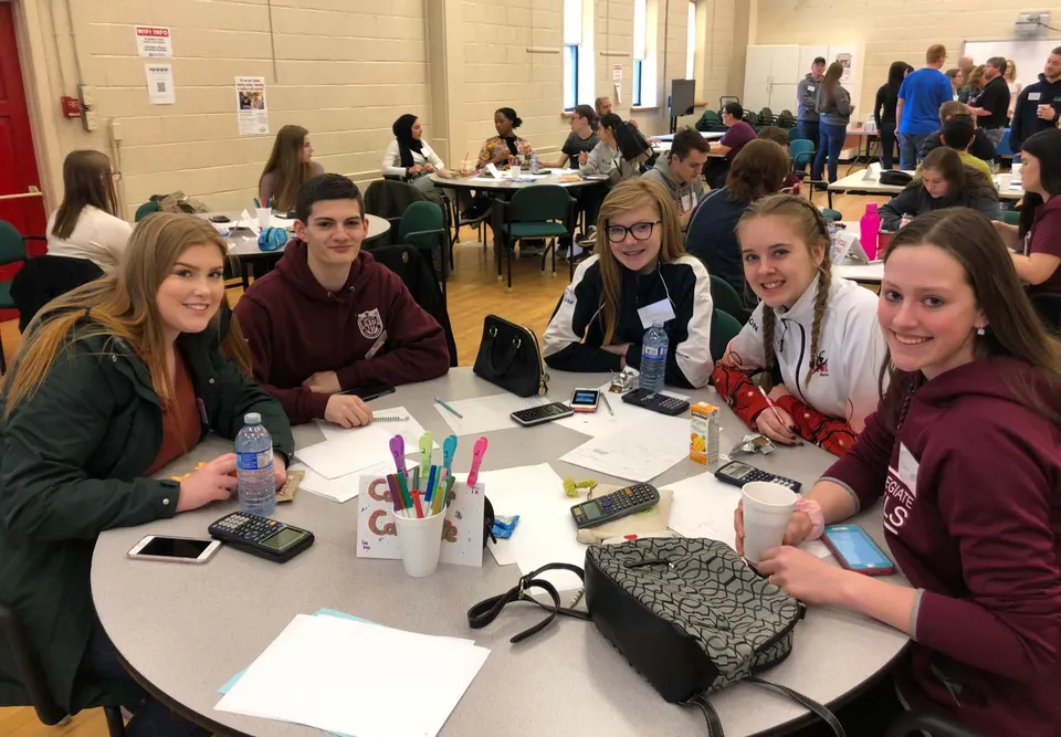 Un gruppo di studenti della Carbonear Collegiate High School lavora insieme a un tavolo in un ambiente scolastico.