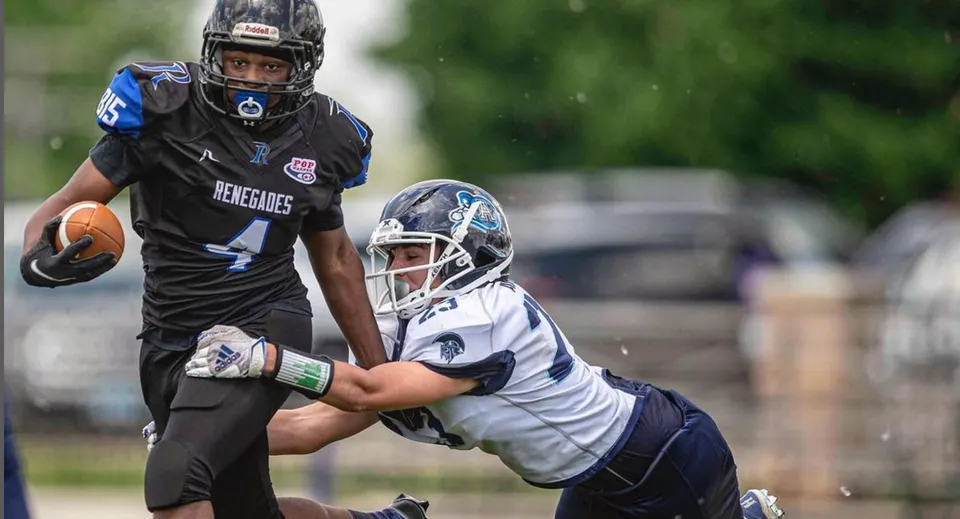 Due giocatori di football della Rockford Lutheran School lottano per la palla sul campo da gioco.