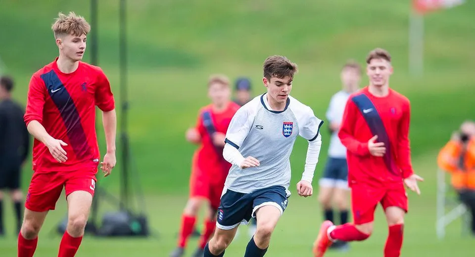 Giocatori di calcio dell'East Sussex College Lewes corrono su un campo in erba durante una partita.