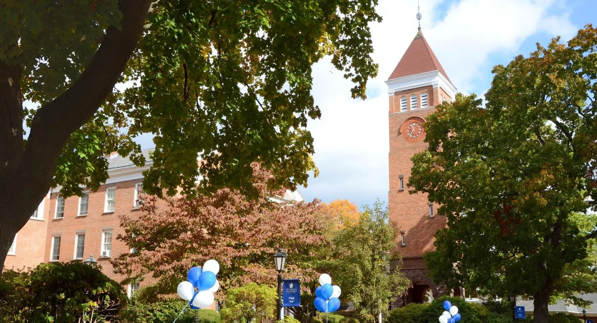 L'edificio in mattoni con una guglia appuntita nel campus della Wyoming Seminary College Preparatory è circondato da alberi verdi.