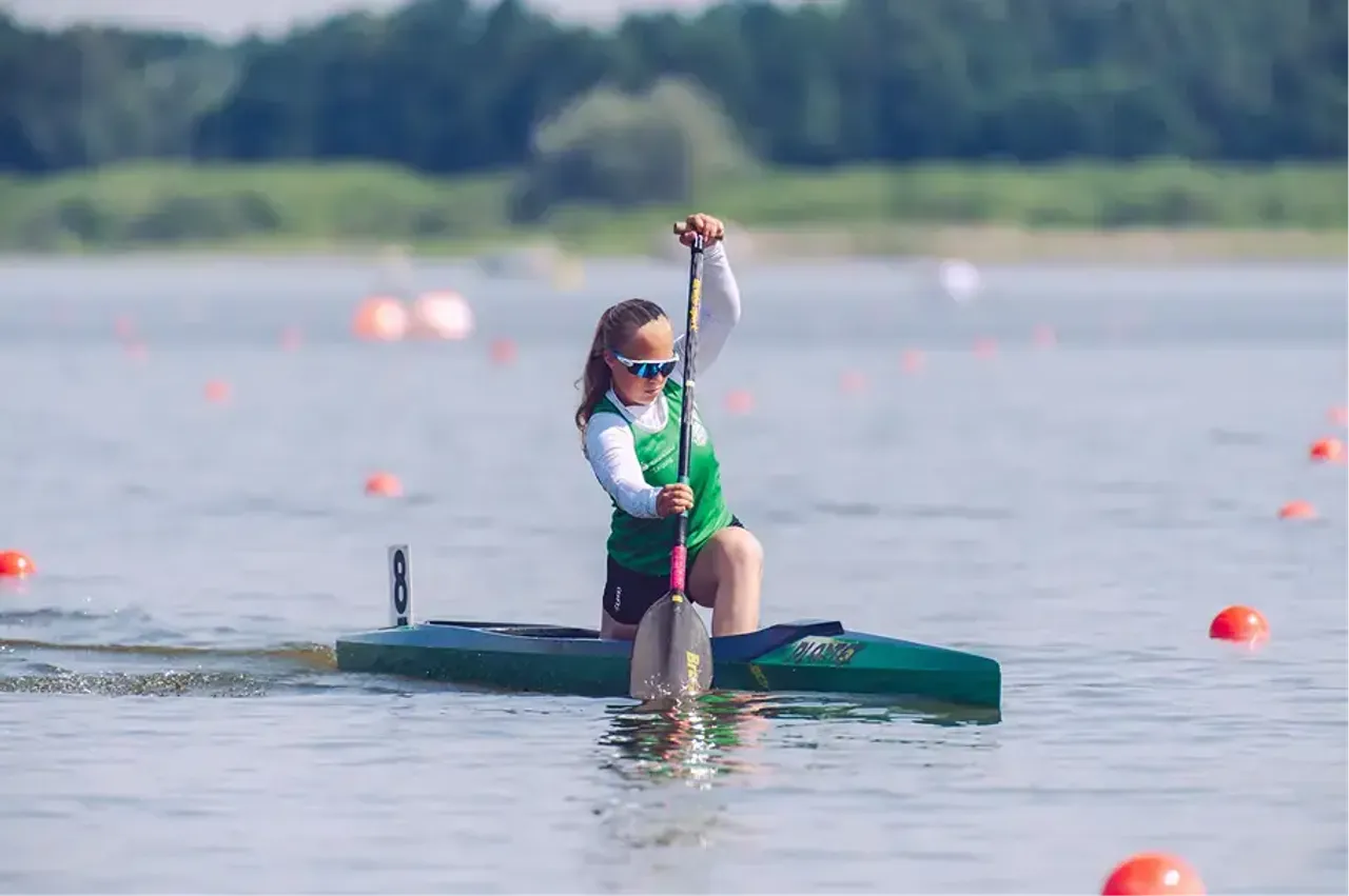 Studentessa in canoa si allena con la pagaia su un lago