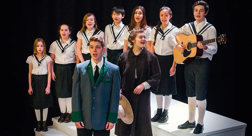 Studenti della Abbotsford School of Integrated Arts sul palco con strumenti musicali durante un'esibizione.