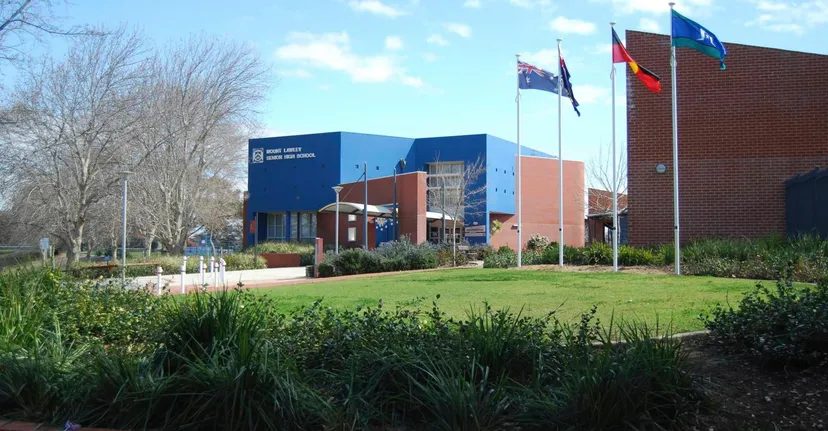 L'edificio scolastico moderno della Mount Lawley Senior High School si trova in un'area verde ben curata con alberi e bandiere internazionali.