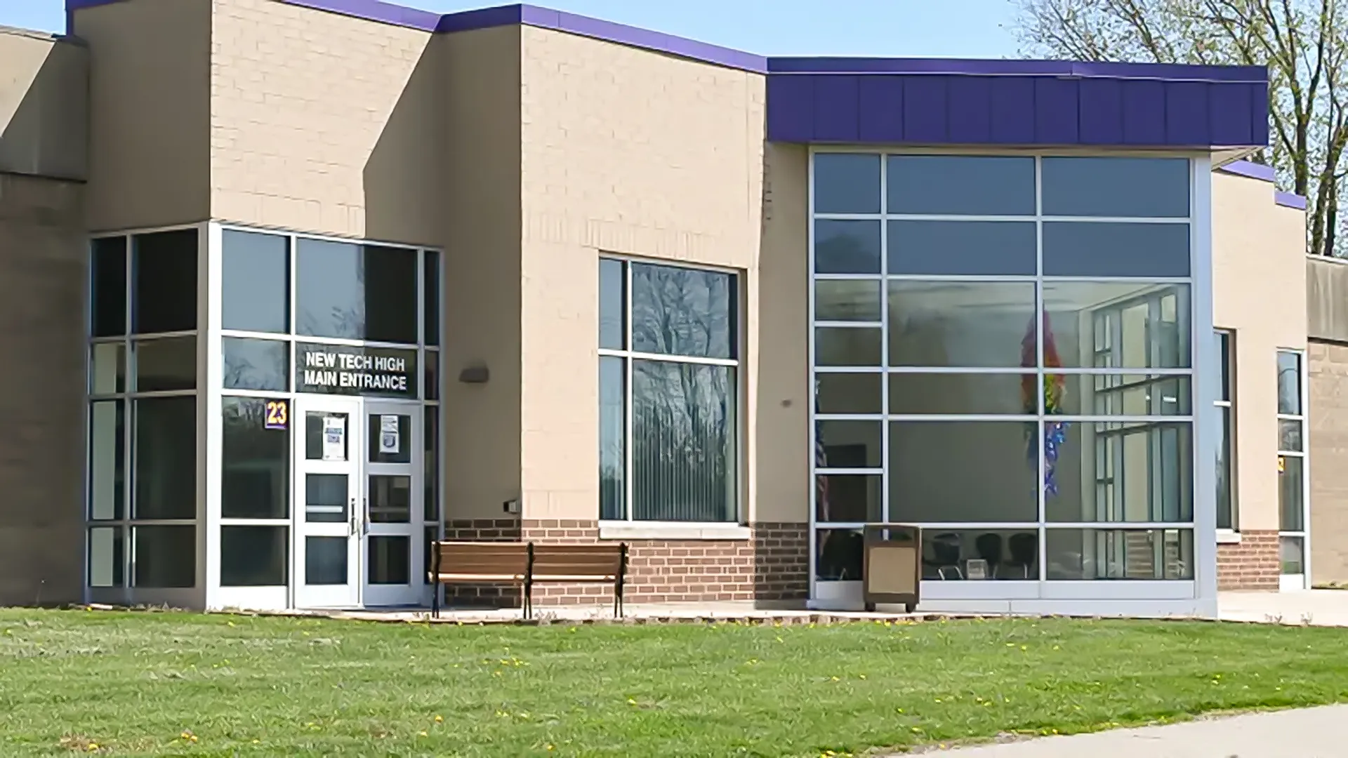 L'edificio moderno a più piani della Scottsburg High School con facciata in vetro e un'area verde in primo piano.