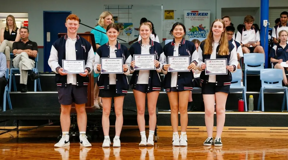 Un gruppo di giovani studentesse della Leeming Senior High School con degli attestati si trova in una palestra.