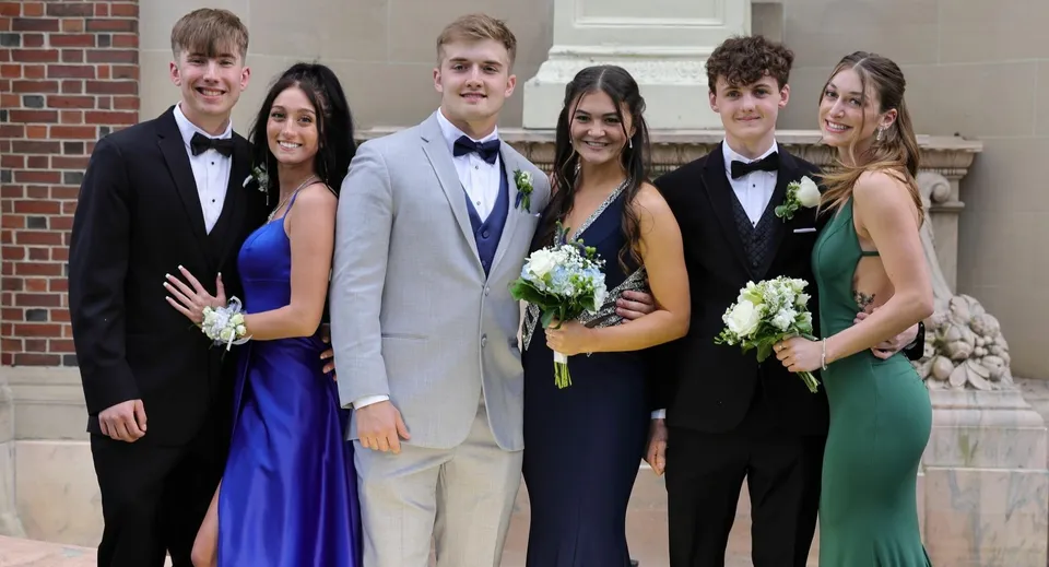 Un gruppo di studenti della New Hampton School posa in modo formale davanti a un edificio in mattoni.