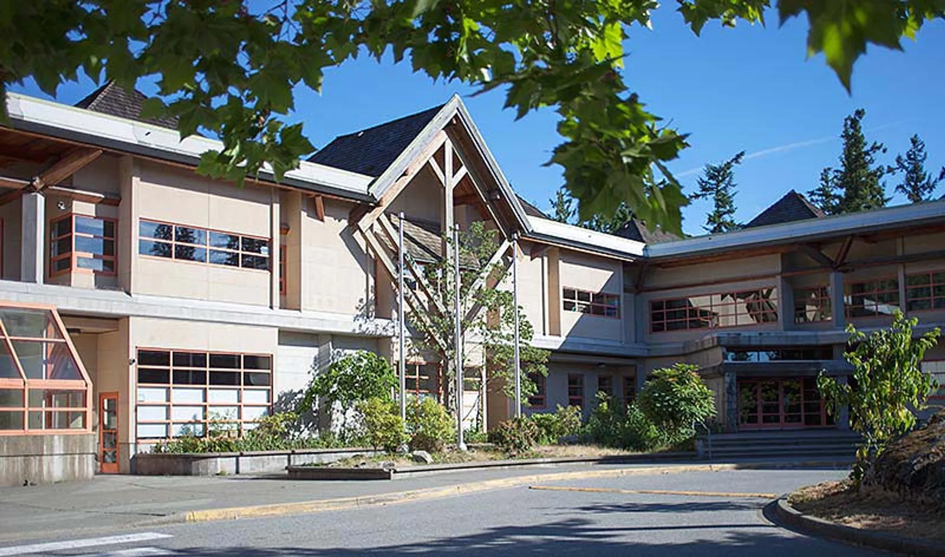 L'edificio moderno a più piani della Rockridge Secondary School è circondato da un verde rigoglioso e da un cielo azzurro.