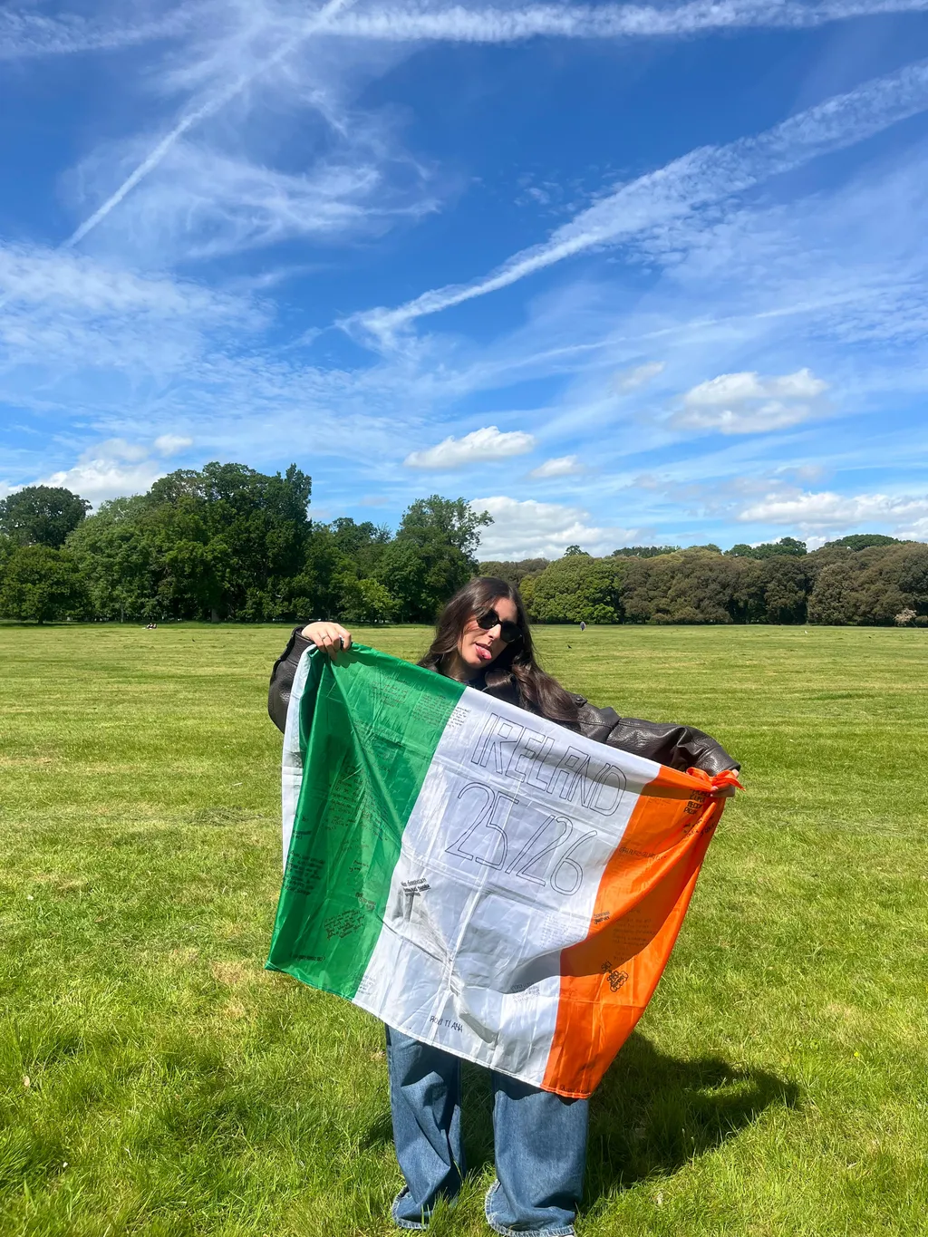 Studentessa con la bandiera irlandese in un prato durante un anno scolastico in Irlanda