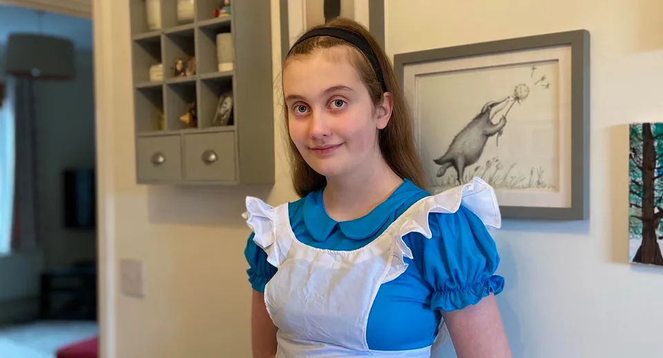 Una giovane donna si trova in una stanza con scaffali e un'opera d'arte alla parete nel campus della Brookes UK.