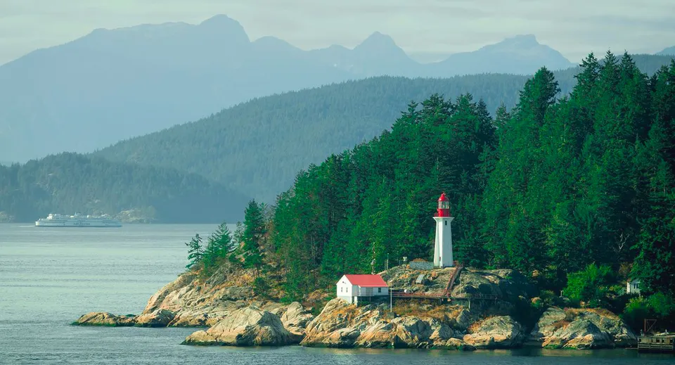 Paesaggio costiero con faro e montagne sullo sfondo vicino alla Centennial Secondary School in British Columbia.