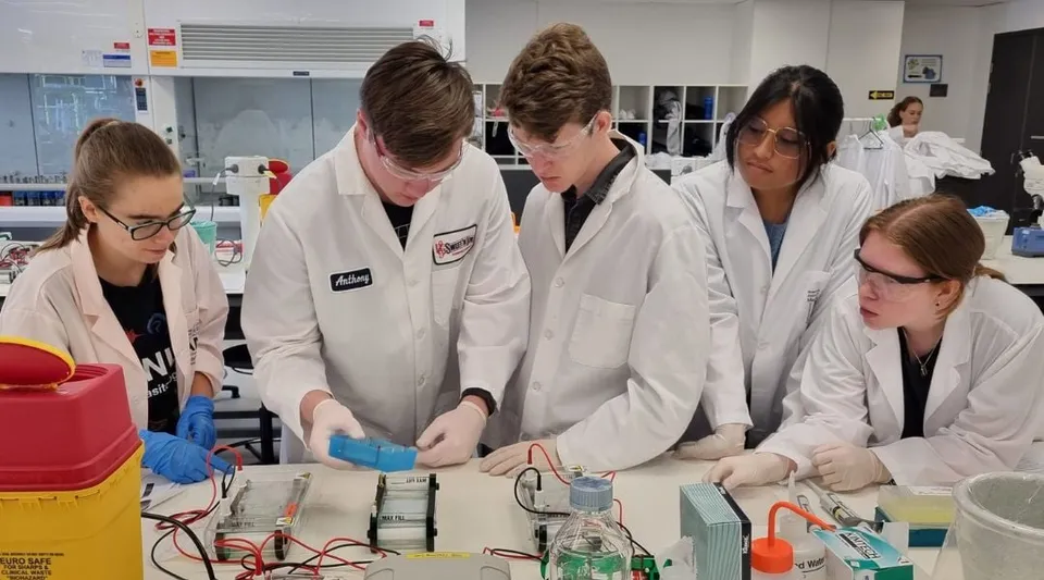 Studenti della UC-Lake Ginninderra svolgono insieme un esperimento nel laboratorio scientifico.