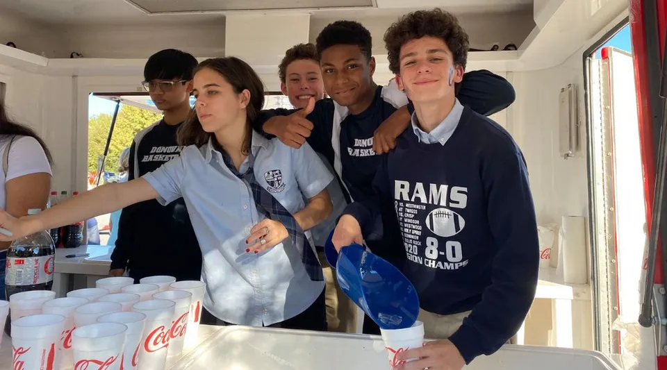 Un gruppo di studenti della Monsignor Donovan Catholic High School posa insieme in una cucina.