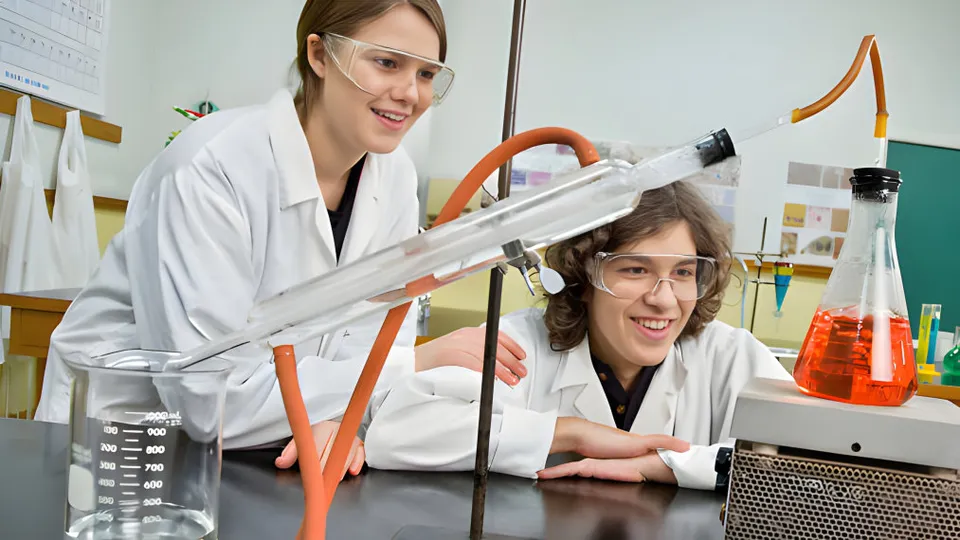 Due studentesse del Collège Sainte-Anne lavorano insieme a un esperimento scientifico in laboratorio.