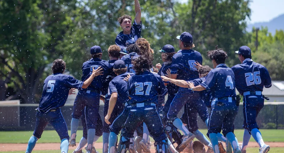 Studenti della Indooroopilly State High School festeggiano insieme all'aperto sul campo da baseball.