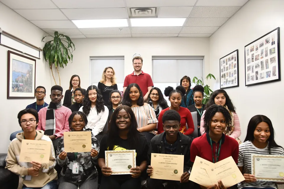 Studenti e insegnanti del Great Lakes College of Toronto ricevono certificati e riconoscimenti in ufficio.