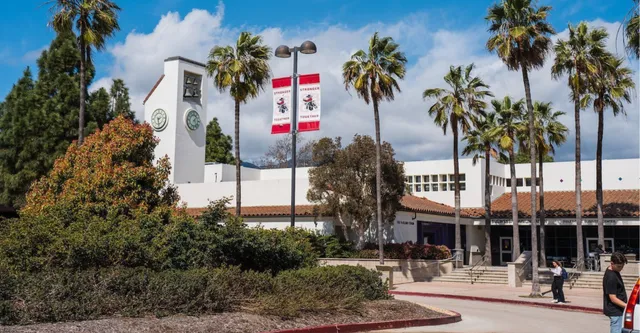 L'edificio principale bianco con torre dell'orologio nel campus del Santa Barbara City College è circondato da palme e un sentiero.