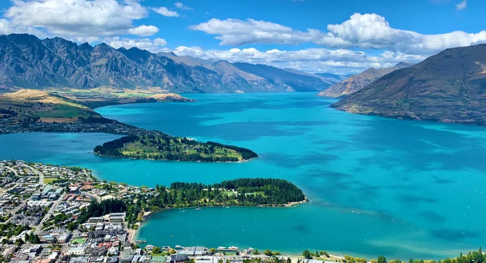 Vista aerea di un pittoresco lago con montagne e paesaggio verde nei pressi del Kaipara College.