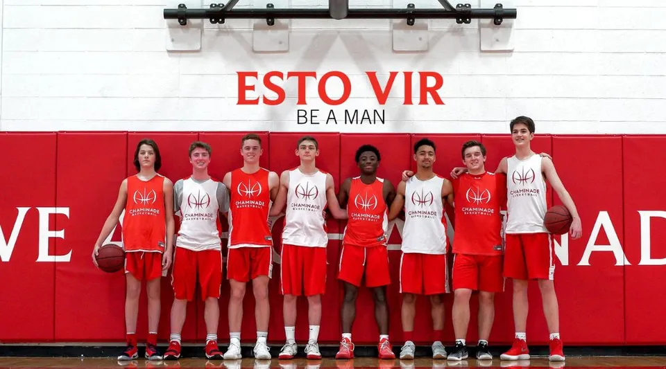 La squadra di pallacanestro della Chaminade College Preparatory School posa insieme davanti a uno sfondo rosso con la scritta ESTO VIR BE A MAN.