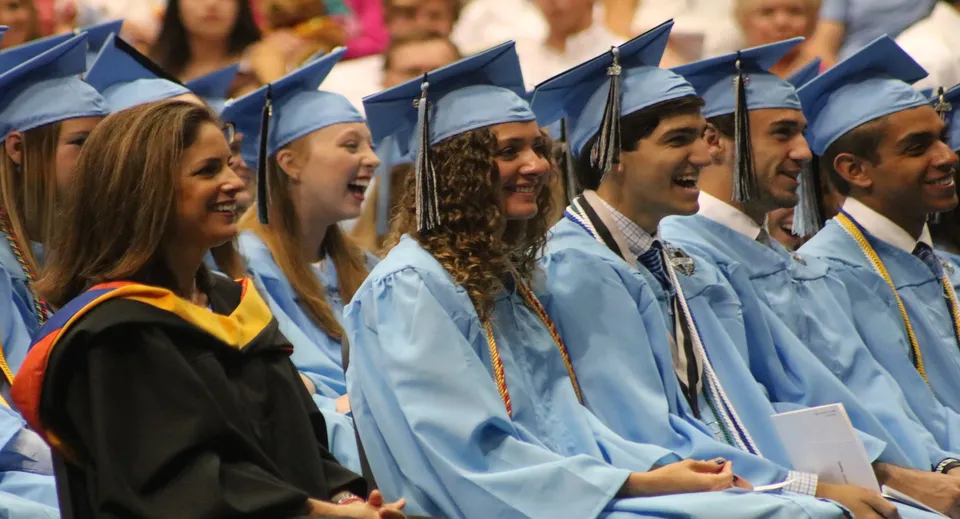 Un gruppo di diplomati del Chesterfield School District in toga blu e nera festeggia insieme il diploma.