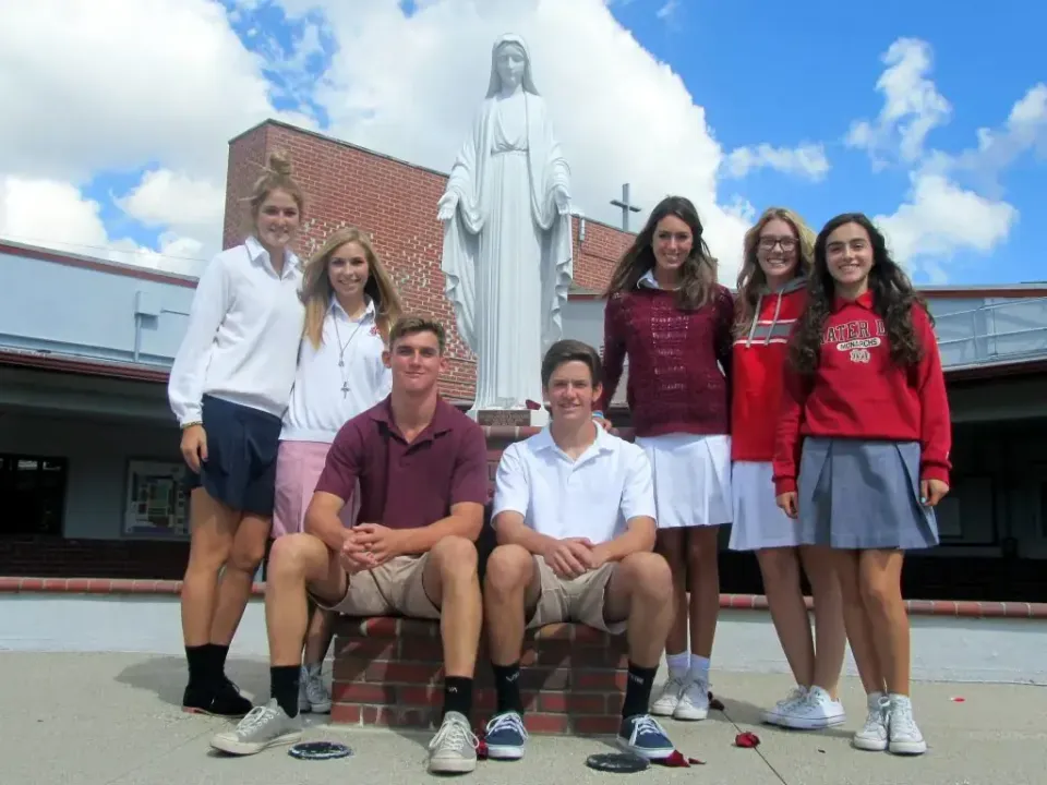 foto di gruppo USA davanti a statua cristiana