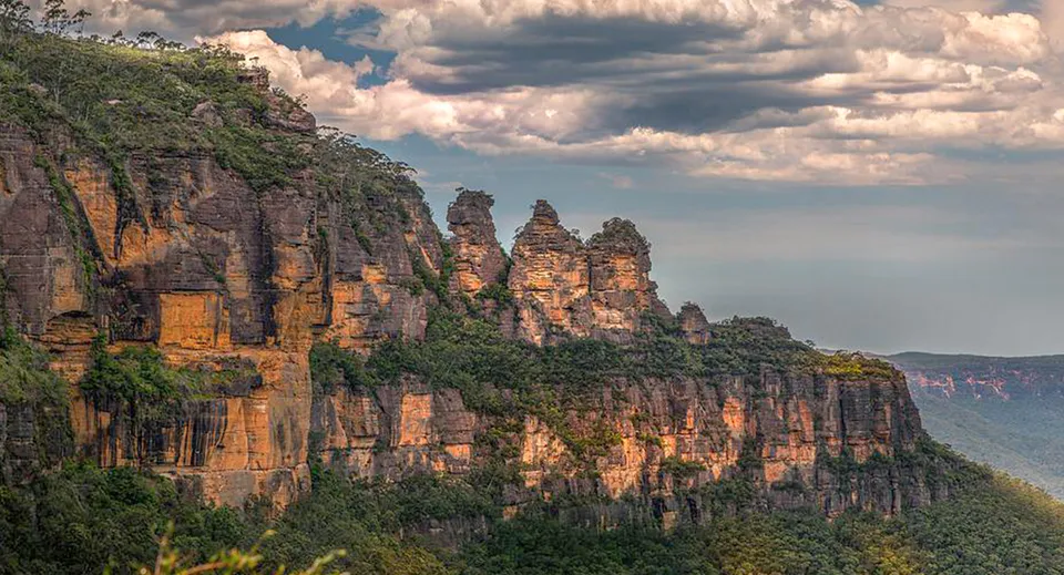 Formazioni rocciose si ergono sotto un cielo nuvoloso nell'ambiente naturale della Maryborough State High School.
