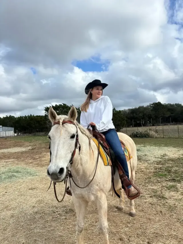 Studentessa con cappello da cowboy a cavallo in un ranch negli Stati Uniti