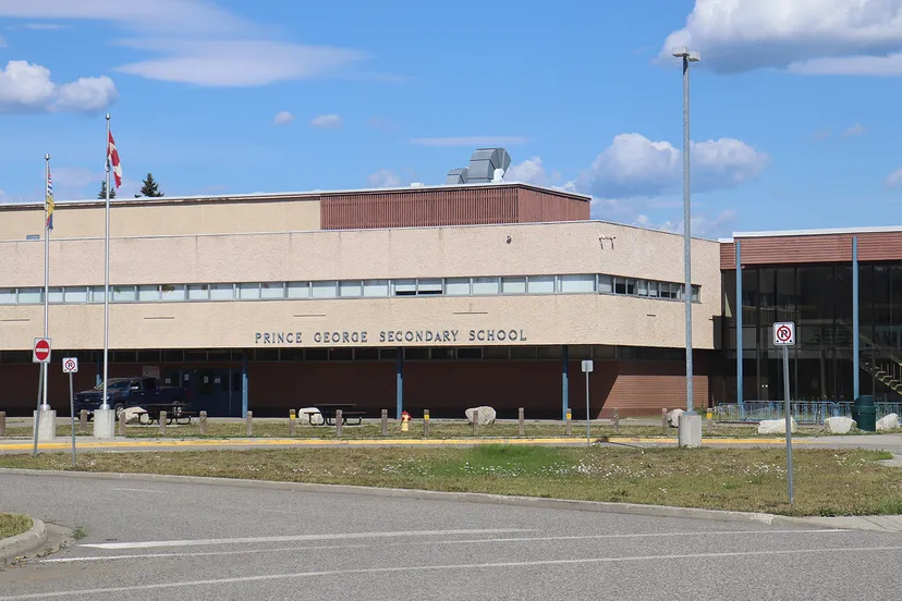 L'edificio scolastico moderno della Prince George Secondary School è circondato da un prato e da una strada.