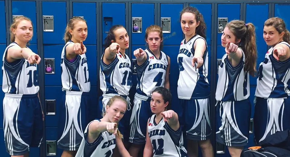 Un gruppo di giovani atlete della Nechako Valley Secondary School posa insieme nello spogliatoio in abbigliamento sportivo.