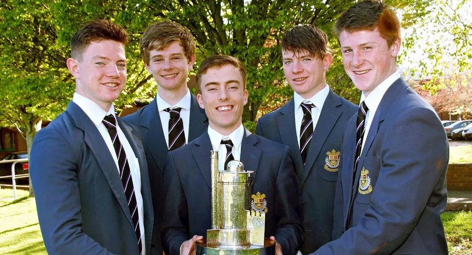 Studenti del Presentation College Galway posano all'aperto insieme a un trofeo.