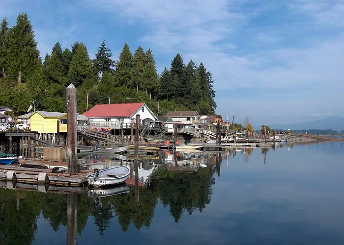 Una vista tranquila del agua con edificios coloridos y barcos cerca de la Cowichan Secondary School en una zona boscosa verde.