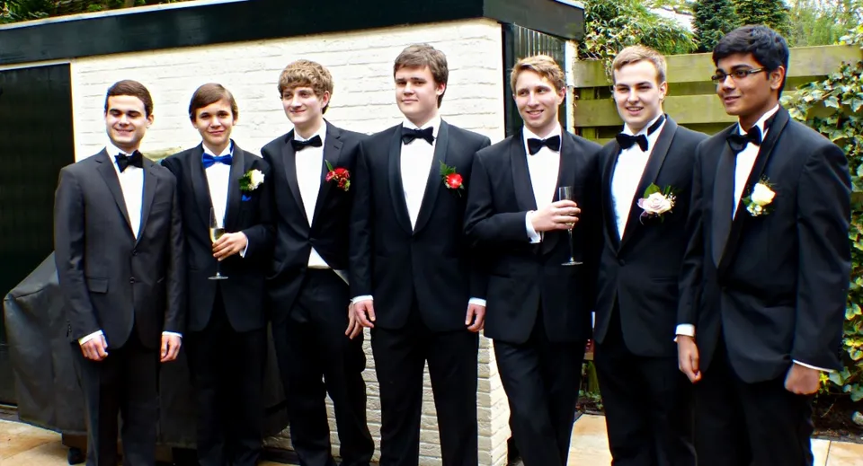 Un gruppo di studenti maschi in abito formale è all'aperto nel terreno del St. Marys College Galway.