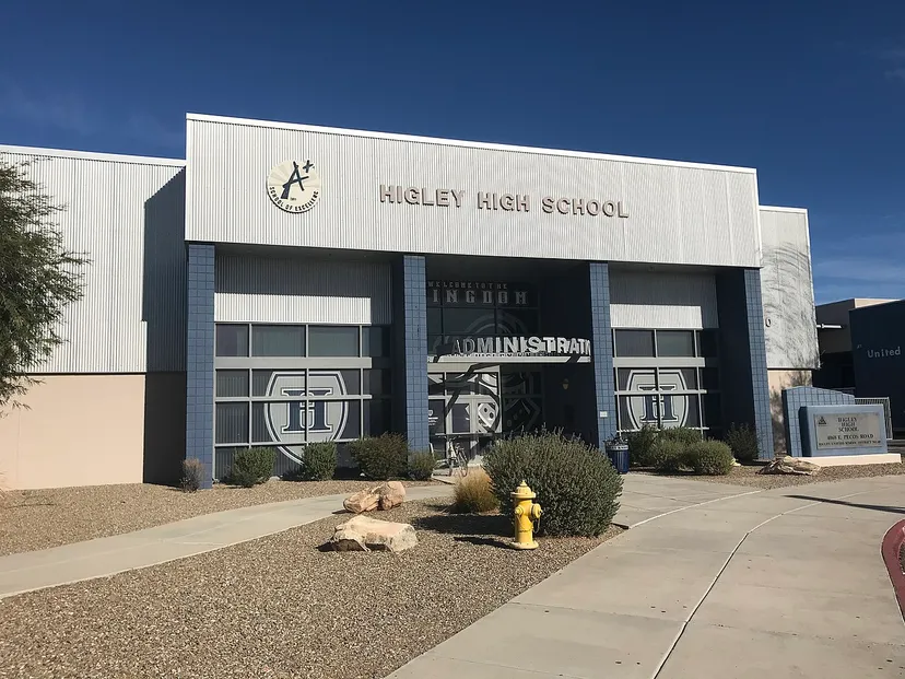 Il moderno edificio scolastico bianco della Hagley High School è circondato da cespugli e pietre in primo piano.