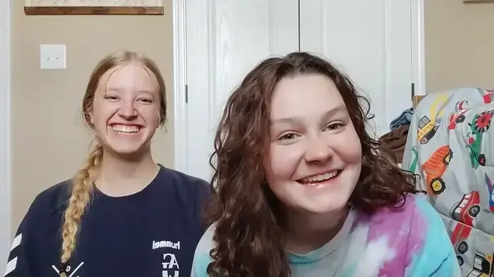 Valenia und ihre Mitschülerin lachen gemeinsam, Vorschaubild des Erfahrungsvideos