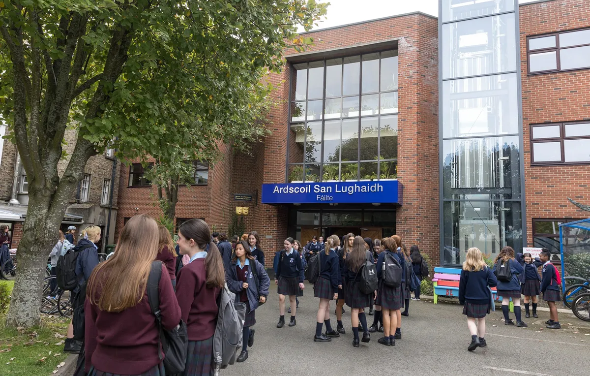 Estudiantes con uniforme ante la entrada de la St. Louis High School en Dublín