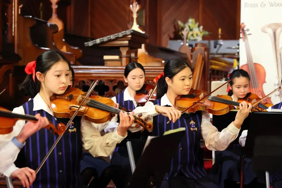 Studentesse della Diocesan School For Girls suonano insieme il violino in un'aula di musica.